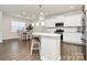 Bright open kitchen with white cabinets, stainless steel appliances, an island, and an adjacent dining area at 913 Deep River Way, Waxhaw, NC 28173