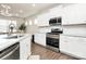 Well-equipped kitchen featuring stainless steel appliances, white cabinets, and sleek countertops at 913 Deep River Way, Waxhaw, NC 28173