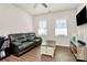 Cozy living room features a dark leather sofa, center table and mounted TV for entertainment at 913 Deep River Way, Waxhaw, NC 28173