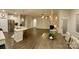 Open-concept living space with wood floors flows from kitchen to dining area with modern lighting at 913 Deep River Way, Waxhaw, NC 28173