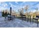 Outdoor patio featuring a stone paver floor with dining and bar seating under a partly cloudy sky at 913 Deep River Way, Waxhaw, NC 28173