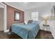 Bedroom with a double bed, side table and terracotta colored accent wall at 128 Hugh Caldwell Rd, Charlotte, NC 28214