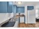 Efficient kitchen with blue cabinets and stainless steel appliances at 128 Hugh Caldwell Rd, Charlotte, NC 28214