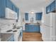 Modern kitchen with blue cabinets, white appliances, and wood floors at 128 Hugh Caldwell Rd, Charlotte, NC 28214