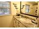 Charming bathroom featuring a marble vanity countertop, white cabinets, and a large mirror at 13538 Pine Harbor Rd, Charlotte, NC 28278