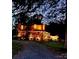 Inviting two-story home featuring a charming, covered porch and professional landscape lighting at twilight at 13538 Pine Harbor Rd, Charlotte, NC 28278