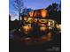 Inviting two-story home featuring a charming, covered porch and professional landscape lighting at twilight at 13538 Pine Harbor Rd, Charlotte, NC 28278