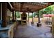 Outdoor kitchen with a stone fireplace, built-in grill, and bar seating area at 13538 Pine Harbor Rd, Charlotte, NC 28278