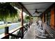 Spacious covered porch with rocking chairs, hanging plants, and wooden railings, perfect for relaxing outdoors at 13538 Pine Harbor Rd, Charlotte, NC 28278