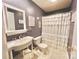 Clean bathroom with white sink, ruffled shower curtain, and tiled floor at 141 Byers Rd, Troutman, NC 28166