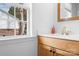 Bathroom with natural wood vanity, white countertops, and a window that offers an exterior view at 141 Byers Rd, Troutman, NC 28166