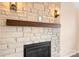 Close up of a stone fireplace with a wooden mantel and sconce lighting at 141 Byers Rd, Troutman, NC 28166