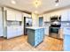 Modern kitchen with white cabinets, a teal island, and stainless steel appliances at 141 Byers Rd, Troutman, NC 28166