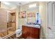 Bathroom featuring a glass shower, granite countertop vanity, and elegant floral art pieces on the wall at 210 N Church St # 2702, Charlotte, NC 28202