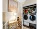 Chic laundry area featuring modern front-load washer and dryer, stylish console table with lamps, and eye-catching artwork at 210 N Church St # 2702, Charlotte, NC 28202