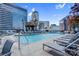 City rooftop pool with sun loungers surrounded by vibrant skyline views and greenery at 210 N Church St # 2702, Charlotte, NC 28202