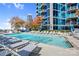 Luxury building rooftop pool with lounge chairs, umbrellas, and skyline views at 210 N Church St # 2702, Charlotte, NC 28202