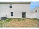 Back exterior of the home, featuring a fenced yard, small patio, and back door at 2117 Talbert Ct, Charlotte, NC 28214