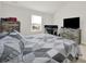 Comfortable bedroom with natural light features a bed with a stylish gray quilt, a desk and dresser at 2117 Talbert Ct, Charlotte, NC 28214