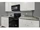 Well-equipped kitchen with black appliances, white cabinets, and durable countertops at 2117 Talbert Ct, Charlotte, NC 28214