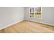 Simple bedroom with hardwood floors and a large window looking out to the trees outside at 2205 Catalina Ave, Charlotte, NC 28206