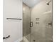 Neutral colored bathroom with a glass shower, built-in shelving, and black hardware at 2205 Catalina Ave, Charlotte, NC 28206