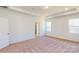 A spacious carpeted bedroom featuring tray ceilings, recessed lights, and abundant natural light at 251 Winford Rd, Troutman, NC 28116