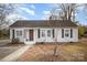 Simple gray house with a brown door and landscaping at 317 W Main St, Marshville, NC 28103