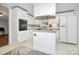 A compact kitchen with white cabinetry, modern appliances, and unique backsplash at 335 Ridgewood Dr, Mt Ulla, NC 28125