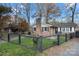 Cute brick home with a black fence and well-manicured lawn at 352 Leafmore Dr, Charlotte, NC 28213