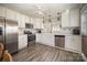 White kitchen with stainless steel appliances and wood flooring at 109 Stonecrest Sw Cir, Concord, NC 28027