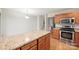 An open kitchen features stainless steel appliances, wooden cabinets, and a granite countertop at 14922 Deshler Ct, Charlotte, NC 28273