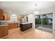 Well-lit kitchen with stainless steel appliances, wooden cabinets, island, and sliding door to the backyard at 14922 Deshler Ct, Charlotte, NC 28273