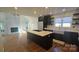 Open-concept kitchen with an island, stainless steel appliances, and a cozy fireplace nearby at 16425 Grapperhall Dr, Huntersville, NC 28078