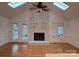 Bright living room featuring a brick fireplace, skylights, and hardwood floors at 16425 Grapperhall Dr, Huntersville, NC 28078