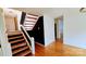 Staircase with unique dark/light steps leading to the upper level and gleaming wood floors at 16425 Grapperhall Dr, Huntersville, NC 28078