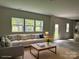 Staged living room showcasing a neutral sofa, wood coffee table, and light-filled windows at 168 Wildwood Loop, Statesville, NC 28625