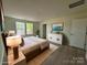 Staged main bedroom showcases a comfortable bed, modern dresser, and lots of light at 168 Wildwood Loop, Statesville, NC 28625
