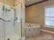 The bathroom boasts a shower and a luxurious soaking tub, creating a perfect relaxation oasis at 25040 Timberlake Dr, Tega Cay, SC 29708