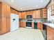 Well-lit kitchen features wood cabinets, modern appliances, and tile flooring for a functional cooking space at 25040 Timberlake Dr, Tega Cay, SC 29708
