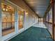 Spacious screened porch with an outdoor ceiling fan, green carpet, and views of nature at 25040 Timberlake Dr, Tega Cay, SC 29708