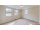 Bright, carpeted bedroom featuring neutral walls, white trim, and large windows, creating a cozy, inviting space at 665 Firecrest Se St, Concord, NC 28025