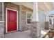 Inviting front porch featuring stone pillar bases, a bright red door, and house number at 109 Obadiah Ct, Troutman, NC 28115