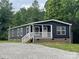 Charming one-story home with navy blue siding, white trim, and a gravel driveway surrounded by lush trees at 1100 Turkey Creek Ridge Rd, York, SC 29745