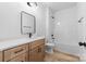 Modern bathroom featuring a wood vanity with light countertop, black fixtures, and tub with shower at 1300 Eddie St, Gastonia, NC 28054