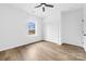 Spacious bedroom featuring wood floors, a ceiling fan, a large window, and closet with white doors at 1300 Eddie St, Gastonia, NC 28054