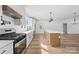 Bright, modern kitchen with white cabinets, an island, and stainless steel appliances on wood floors at 1300 Eddie St, Gastonia, NC 28054