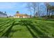 Spacious backyard with a large grassy area and mature trees at 1808 Wilton Gate Dr, Charlotte, NC 28262