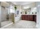 Bright bathroom featuring a walk-in shower, soaking tub, and double vanity with dark wood cabinetry at 6012 Drave Ln, Fort Mill, SC 29715