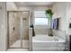 Bathroom featuring a soaking tub, separate shower, and tiled walls at 6012 Drave Ln, Fort Mill, SC 29715